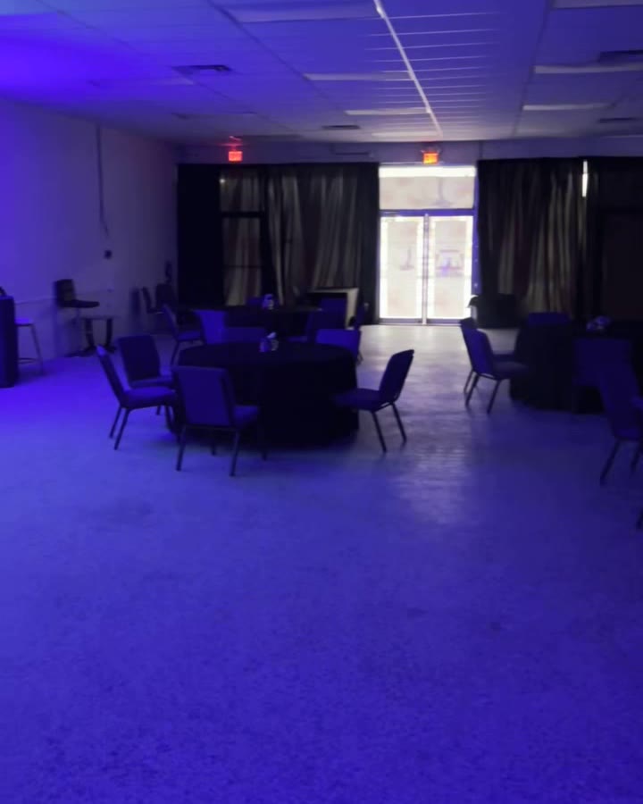 Round tables with black linens and chairs set up across the EBE Center hall